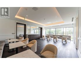 A spacious waiting area with beige chairs and a white counter.