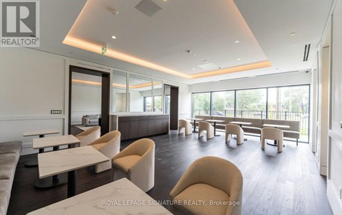 A spacious waiting area with beige chairs and a white counter.