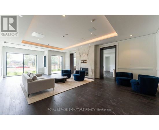 A spacious living room with a couch, chairs, and a fireplace.