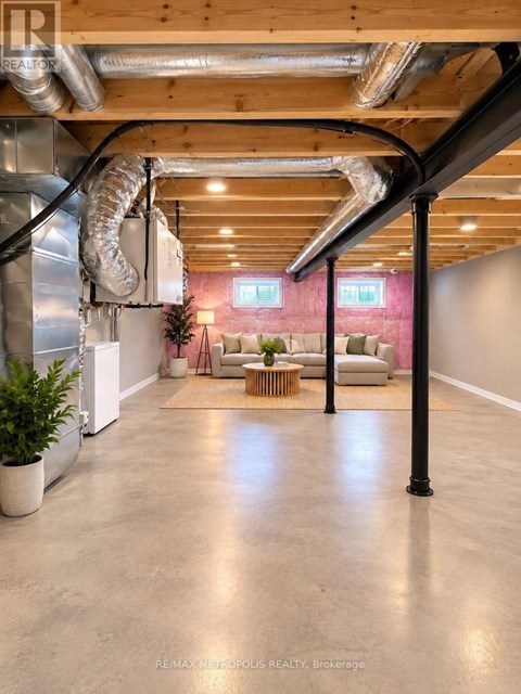 A spacious room with a high ceiling and exposed ductwork.