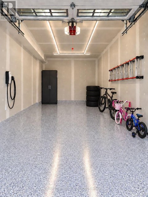 A garage with a grey floor and a black door.