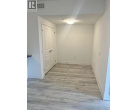 A hallway with a wooden floor and white walls.