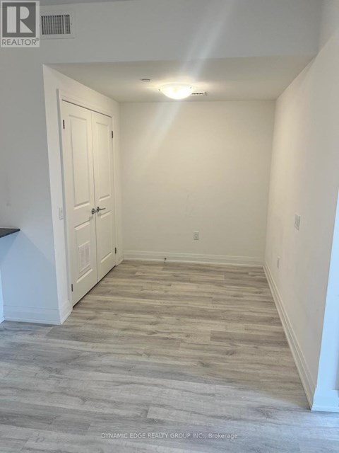 A hallway with a wooden floor and white walls.