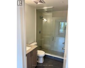 A white toilet in a bathroom with a glass shower door.