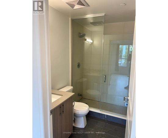 A white toilet in a bathroom with a glass shower door.