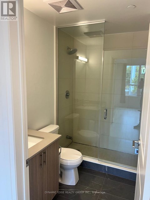 A white toilet in a bathroom with a glass shower door.