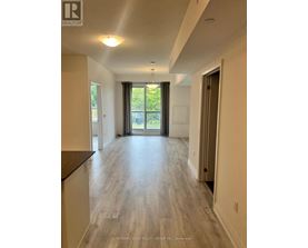 A spacious room with a sliding glass door leading to a balcony.