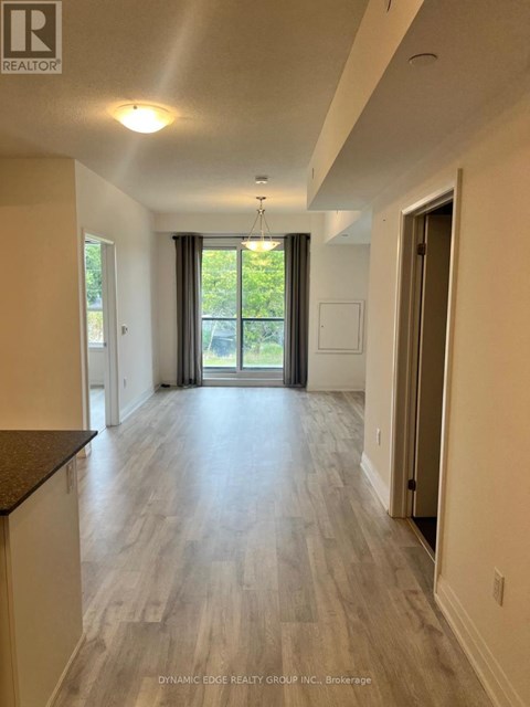 A spacious room with a sliding glass door leading to a balcony.