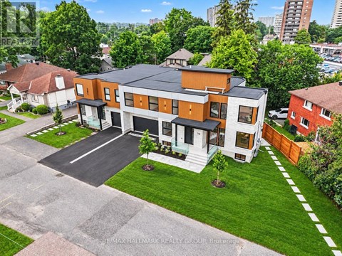A modern two-story house with a large front yard and a driveway.