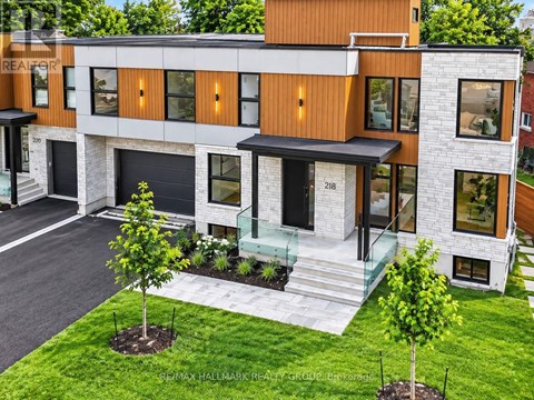 A modern house with a brown and white exterior and a glass door.