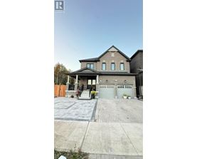 A house with a grey garage door and a brick driveway.
