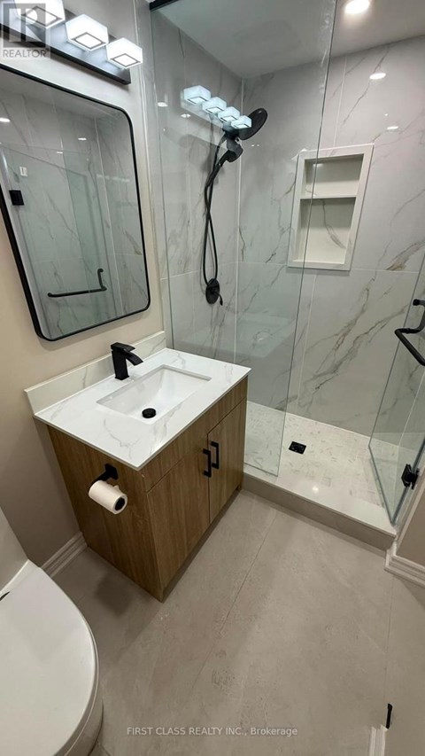 A bathroom with a sink, toilet, and shower.