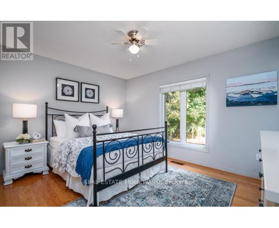 A bedroom with a bed, nightstands, and a ceiling fan.