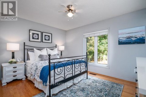 A bedroom with a bed, nightstands, and a ceiling fan.