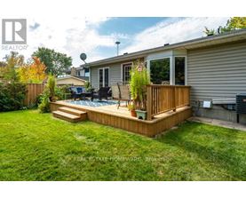 A backyard with a deck and a hot tub.