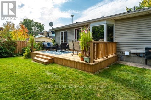 A backyard with a deck and a hot tub.