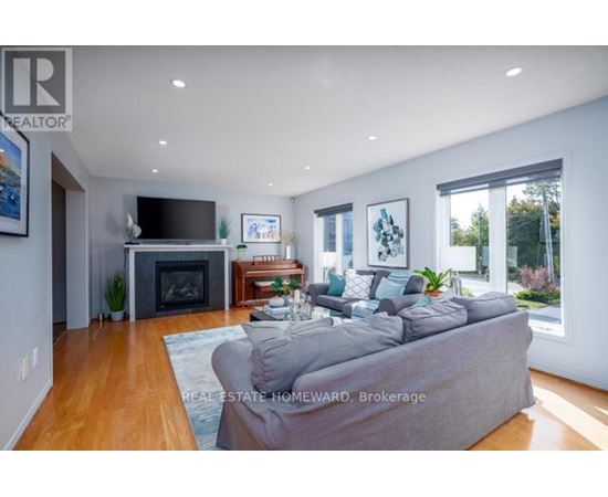 A living room with a grey couch and a fireplace.