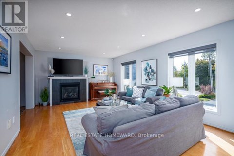 A living room with a grey couch and a fireplace.