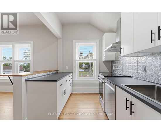 A kitchen with white cabinets and a black countertop.