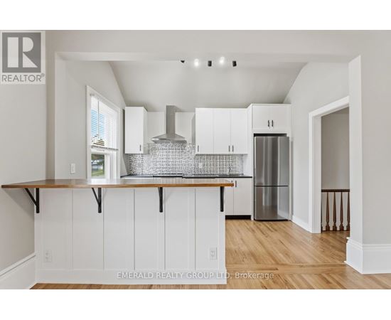A kitchen with white cabinets and a wooden counter top.