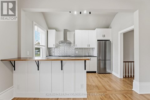 A kitchen with white cabinets and a wooden counter top.