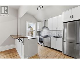A kitchen with white cabinets and a wooden countertop.