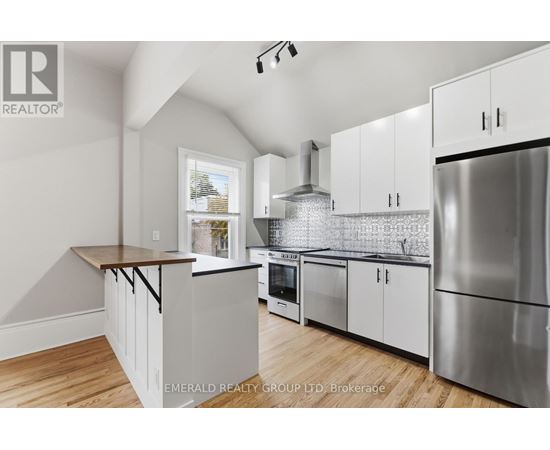 A kitchen with white cabinets and a wooden countertop.