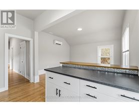 A kitchen with white cabinets and a black countertop.