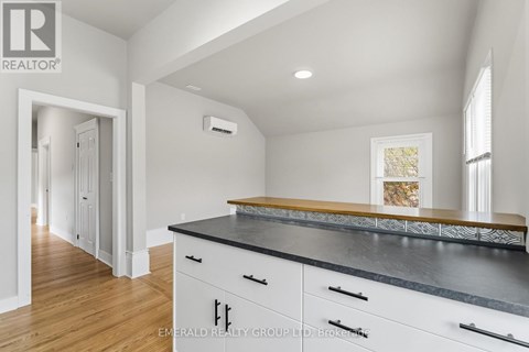 A kitchen with white cabinets and a black countertop.