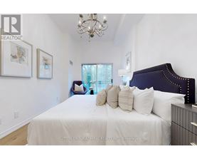 A bedroom with a large bed and a chandelier.