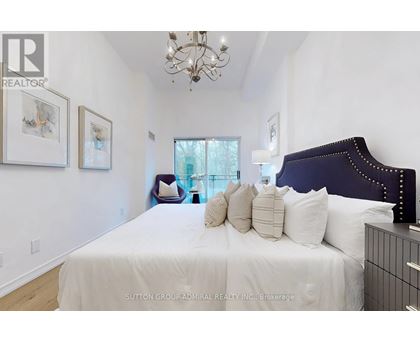 A bedroom with a large bed and a chandelier.