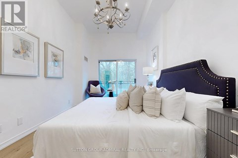 A bedroom with a large bed and a chandelier.