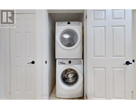 A white washing machine is in a small space between two doors.