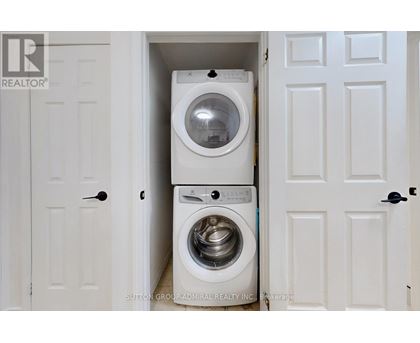 A white washing machine is in a small space between two doors.