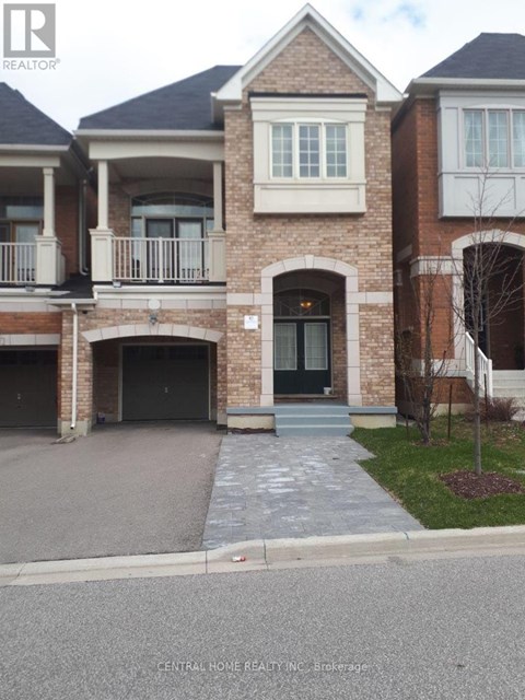 A brick house with a black door and a balcony.