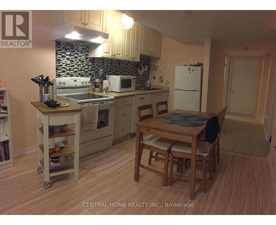 A kitchen with a table and chairs.