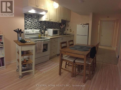 A kitchen with a table and chairs.
