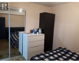 A bedroom with a bed, a dresser, and a wardrobe.