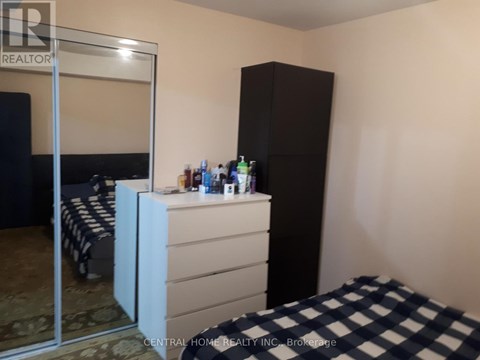 A bedroom with a bed, a dresser, and a wardrobe.