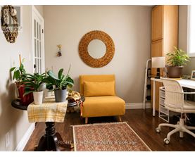 A yellow chair sits in a room with a mirror and potted plants.