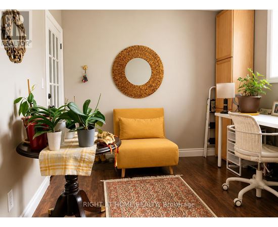 A yellow chair sits in a room with a mirror and potted plants.