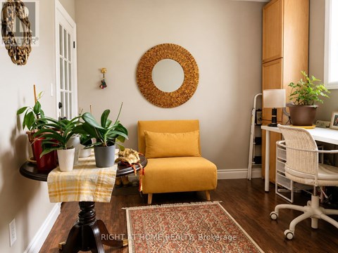 A yellow chair sits in a room with a mirror and potted plants.