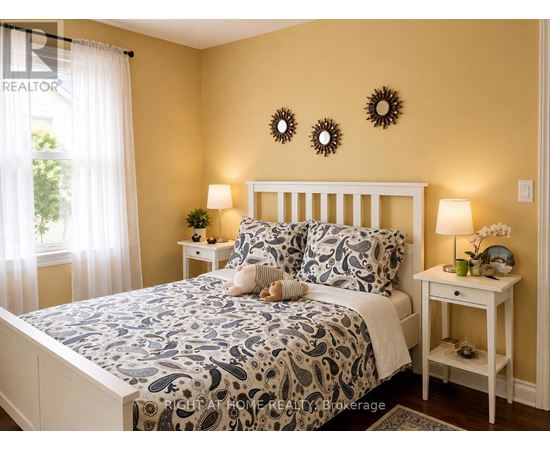 A bedroom with a bed, two lamps, and a nightstand.
