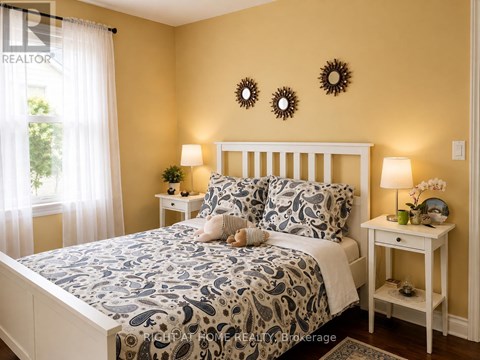 A bedroom with a bed, two lamps, and a nightstand.