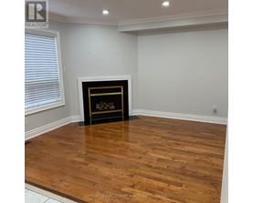 A room with a fireplace and wooden flooring.