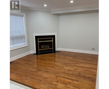 A room with a fireplace and wooden flooring.
