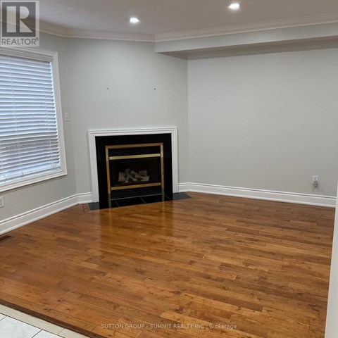 A room with a fireplace and wooden flooring.