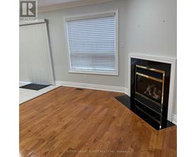 A room with a fireplace and wooden floors.