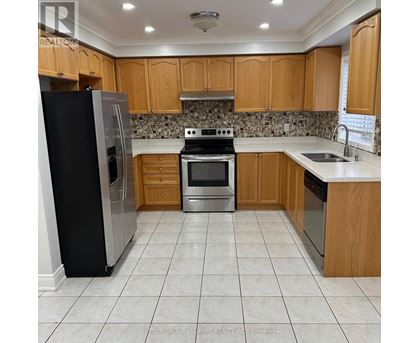 A kitchen with wooden cabinets and a black refrigerator.