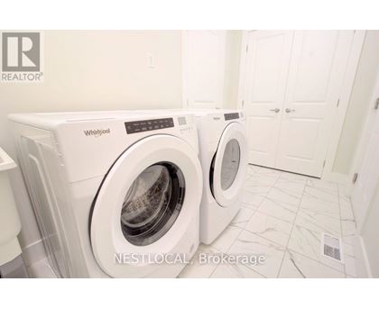 Two white Whirlpool washing machines in a laundry room.